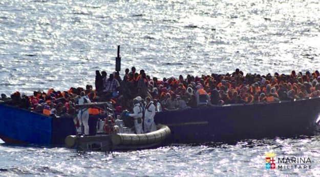 Marinai di Nave Borsini davanti a un barcone con 450 migranti nel Mediterraneo