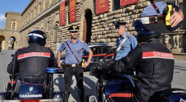 Davanti a Palazzo Pitti a Firenze un capo equipaggio dei carabinieri indossa la pistola elettronica taser